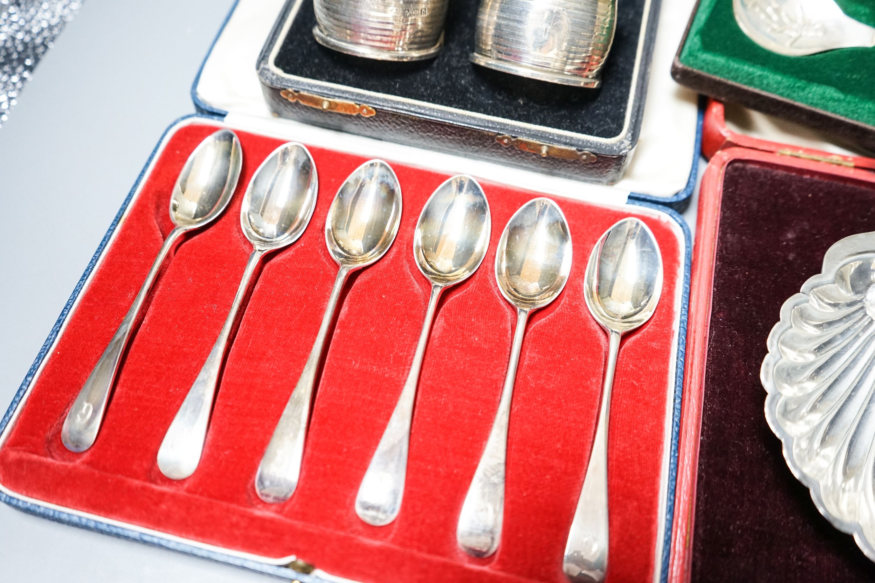 A cased pair of four 1920's silver napkin rings, four other cased items including butter shell and a pair of silver mounted dwarf candlesticks.